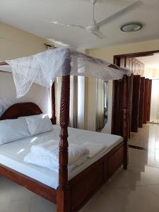 a wooden bed with a canopy in a room at Emirates in Mombasa