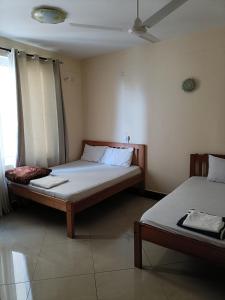 a room with two beds and a window at Emirates in Mombasa