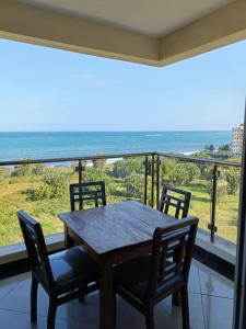 a wooden table with chairs and a view of the ocean at Emirates in Mombasa