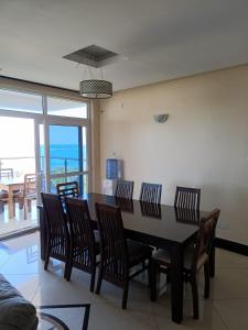 a dining room with a table and chairs and the ocean at Emirates in Mombasa