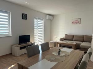 a living room with a table and a couch at Apartman Šarenac in Bileća