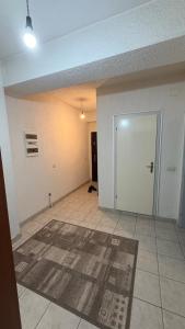 an empty living room with a door and a rug at Coolbnb Apartment Tetovo in Tetovo