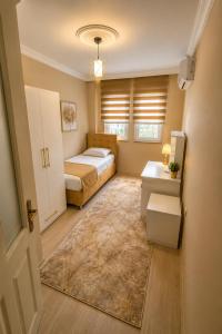 a bedroom with a bed and a desk and a sink at Trabzon Zingila Residence in Yomra