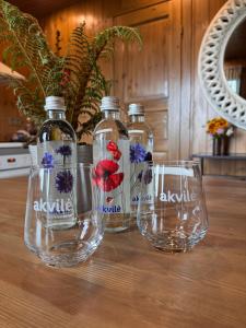 three bottles with flowers on them sitting on a table at Sunset puhkemaja in Kaigutsi