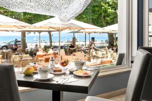 a table with food on it with a view of the beach at Le Beau Séjour in Saint-Raphaël