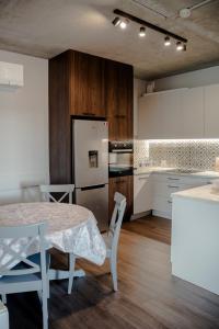 a kitchen with a table and a white refrigerator at Apartamenty 107 in Rumia