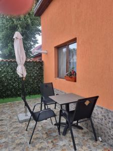 a table and chairs and an umbrella on a patio at Casa Florentina in Făgăraş