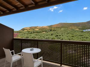 a balcony with a table and chairs and a view at Oasis Apartments & Rooms in Plakias