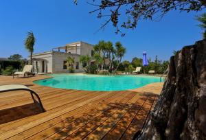 a swimming pool with a wooden deck and a house at Casina Metrano - Castello Monaci in San Pancrazio Salentino +11 photos