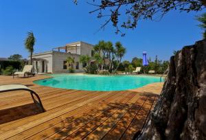 a house with a swimming pool and a wooden deck at Casina Metrano - Castello Monaci in San Pancrazio Salentino