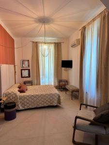 a bedroom with two beds and a tv and a room at Casina Metrano - Castello Monaci in San Pancrazio Salentino