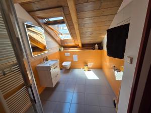 an attic bathroom with a toilet and a window at Apartmán U lípy in Semily