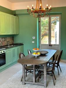 a kitchen with a wooden table with chairs and a chandelier at Casina Metrano - Castello Monaci in San Pancrazio Salentino