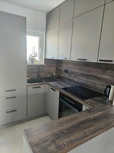 a kitchen with white cabinets and a counter top at Apartment and room Gušćić in Rab