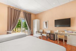 a hotel room with a bed and a flat screen tv at Le Beau Séjour in Saint-Raphaël