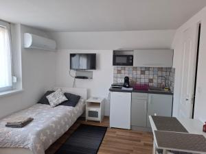 a small room with a bed and a small kitchen at Werner Apartman in Mohács