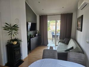 a living room with a couch and a living room with a tv at Apartment and room Gušćić in Rab