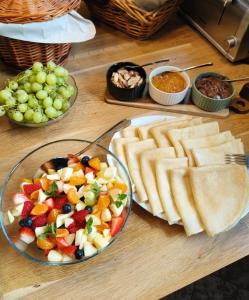 a table with a plate of food with fruit and bread at Wysoka noclegi ze śniadaniem in Krynica Zdrój