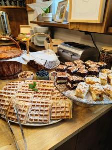 a table with waffles and pastries on a counter at Wysoka noclegi ze śniadaniem in Krynica Zdrój