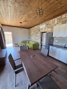a living room with a wooden table and a kitchen at Alyki Stone House 4 in Alyki +7 photos