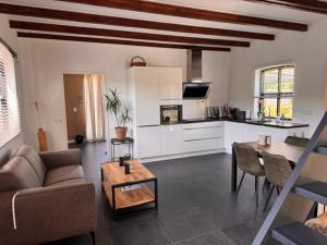 a living room with a couch and a table at Het Atelier Schuring - Luxe vakantiehuis 78m2 in Numansdorp