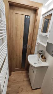 a bathroom with a sink and a wooden door at Sunrise House in Žilina