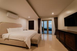 a bedroom with a large bed and a television at Villa 18 Kata-Private Pool Villa with Sea View in Ban Kata