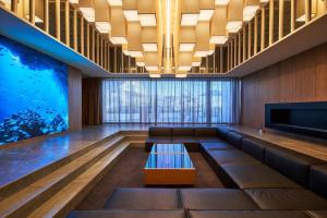 a lobby with a large aquarium in the background at The Blue House in Katsuura