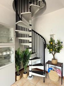 a black and white spiral staircase in a room with plants at 2-Bedroom Airconditioned Lakeview Apartment in Acquaseria