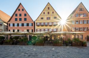 a group of buildings with umbrellas in a courtyard at Meiser Altstadt Hotel in Dinkelsbühl +19 photos
