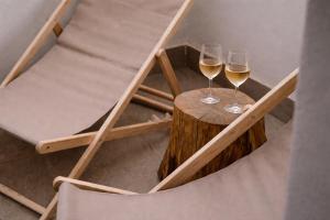 two glasses of white wine sitting on a wooden table at L'ateneo Lumiére in Agrigento