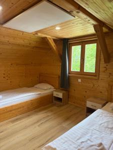 a bedroom with two beds in a wooden cabin at Martinova izba - Family Bungalows in Laško
