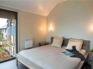 a bedroom with a large bed and a balcony at Lakeside Stay with Sauna in Boussu-lez-Walcourt