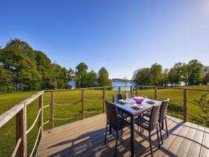 a wooden deck with a table and chairs on it at Lakeside Stay with Sauna in Boussu-lez-Walcourt