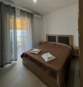 a bedroom with a bed with two towels on it at Tophill Apartments in Borsh