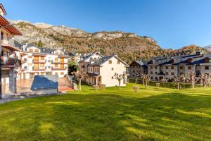 a group of houses in a park with a green lawn at Ibón de tebarray in Escarrilla