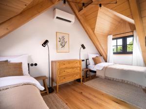 a attic bedroom with two beds and a window at Šimuntov dvor in Nová Baňa