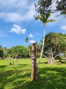 a totem pole in a field with a palm tree at Ratua Private Island Resort in Aimbuei Bay