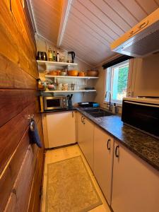 a kitchen with white cabinets and a counter top at Ugglan' in Undenäs