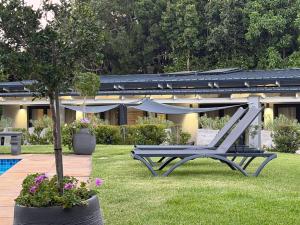 a bench sitting in the grass next to a house at Constantia Winelands Lodge in Constantia