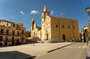 a large building with a clock tower in a street at 'Na Scalunera in Mezzojuso