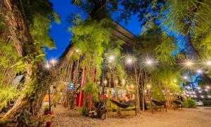 a group of trees with hammocks and lights at Cafe Moto Hostel in Puerto Princesa City