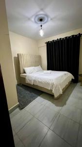 a bedroom with a bed with a black curtain at 2 Bedroom Apartment Kitengela in Kitengela  +2 photos