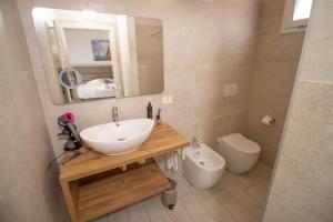 a bathroom with a sink and a toilet at OASI Apartment in Le Grazie