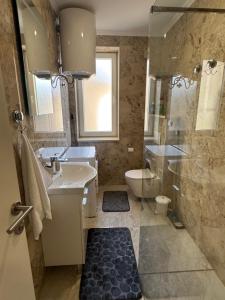 a bathroom with a sink and a toilet and a shower at StanČapljina in Čapljina +28 photos