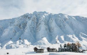 a mountain covered in snow with houses in the foreground at Les Suites – Maison Bouvier in Tignes