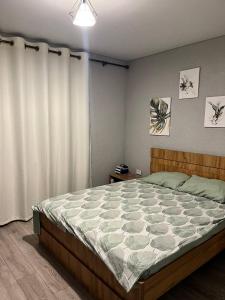 a bedroom with a large bed and a white curtain at FishKa in Cholpon-Ata