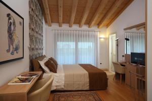 a bedroom with a bed and a desk and a television at Agriturismo Villa Almè in Oderzo