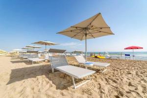 a group of chairs and umbrellas on a beach at Residence Comfort - Nuova gestione in Riccione
