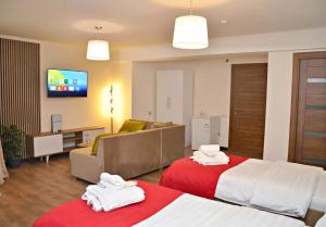 a hotel room with two beds and a couch at Hotel Beli in Tbilisi City